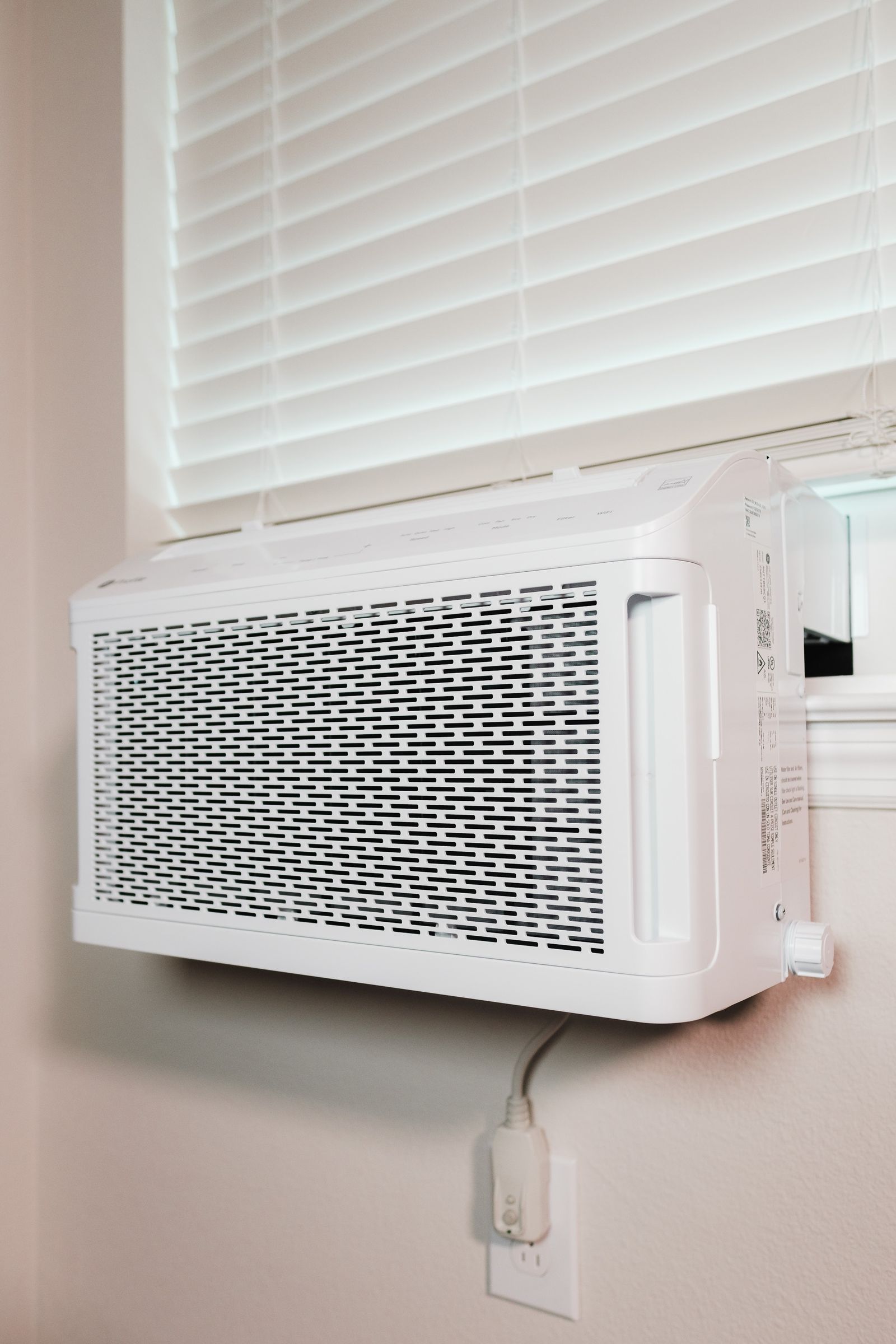 A compact indoor air-conditioning unit installed beneath a window.
