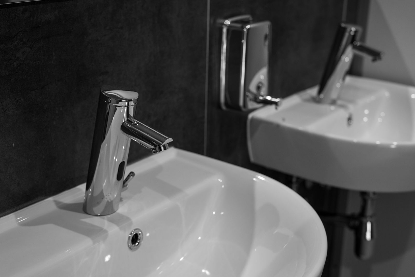 Two modern bathroom basins and chrome faucets in a clean interior.