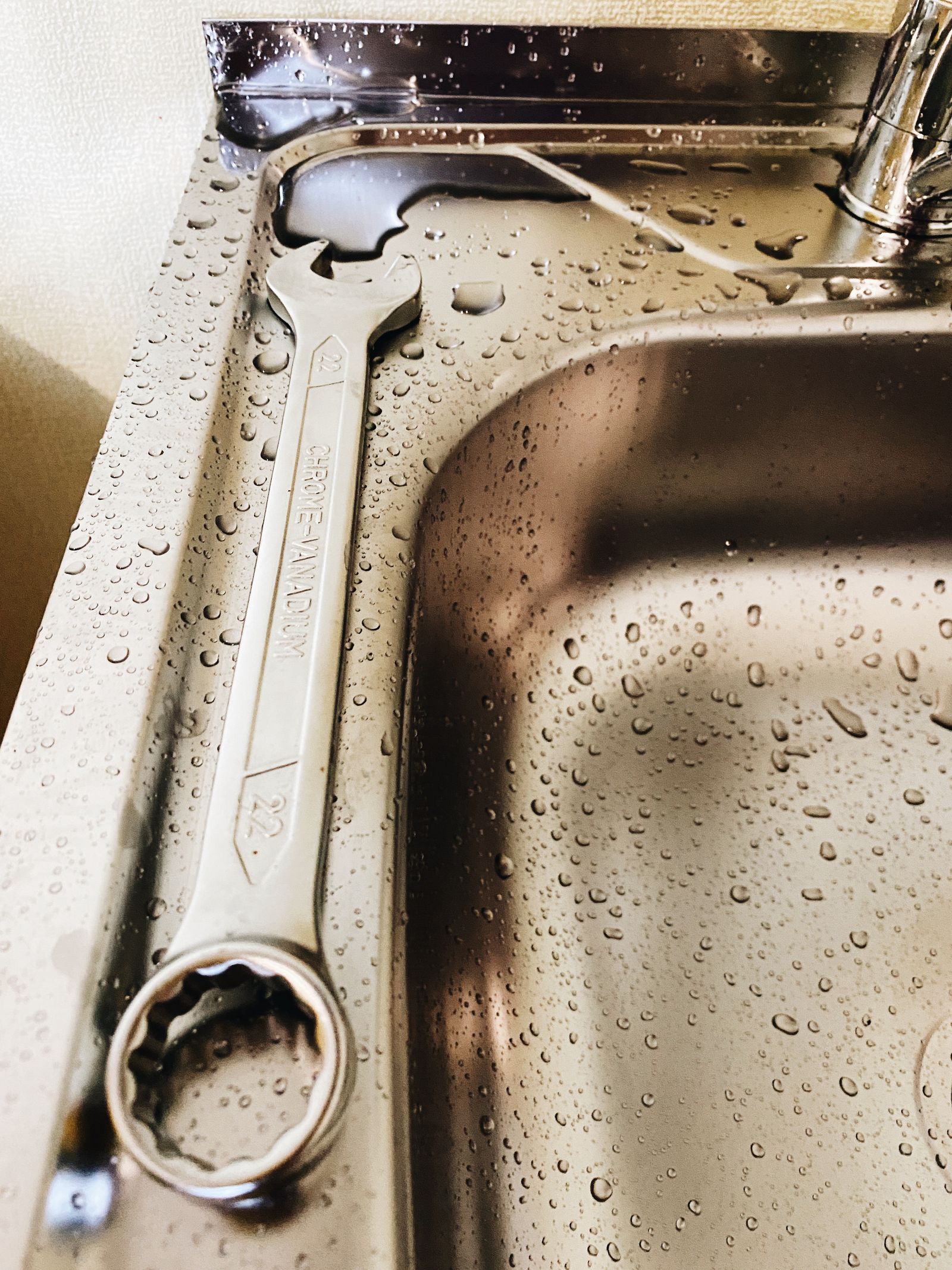 Wrench and sink detail illustrating household fixture service.