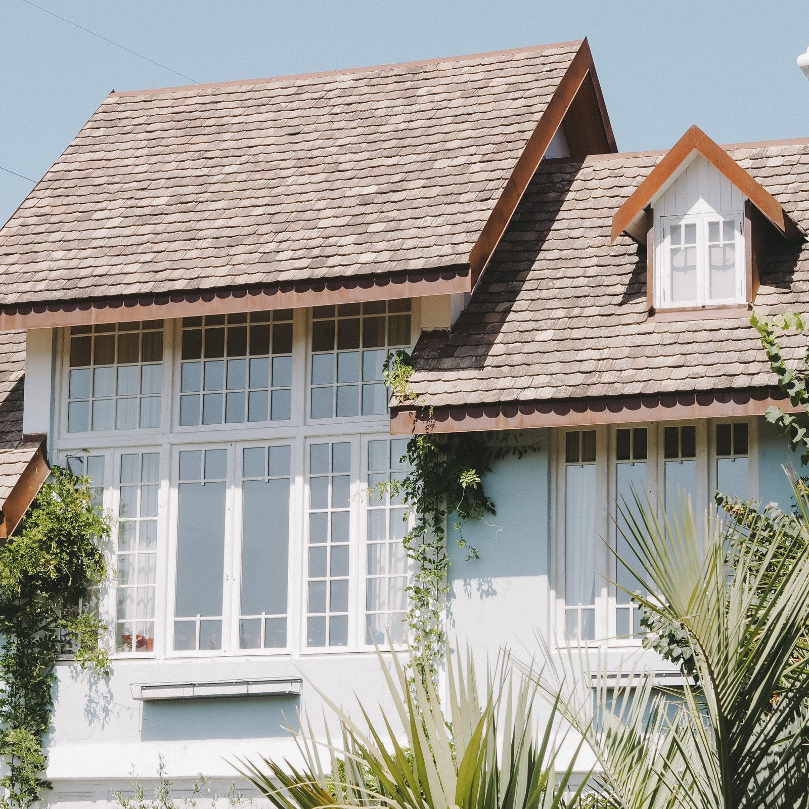 A home with a full roof of light-colored shingles and multiple roof planes.